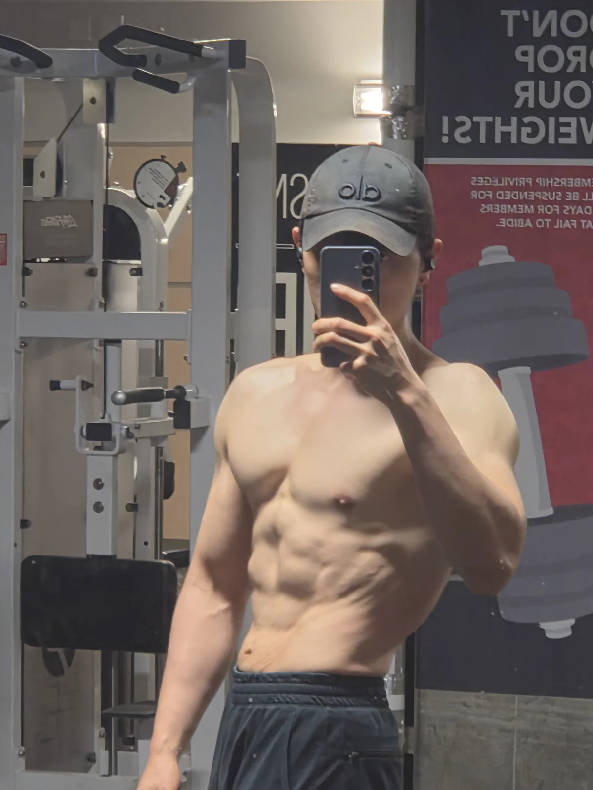 Founder gym mirror physique check-in with visible abdominal definition
