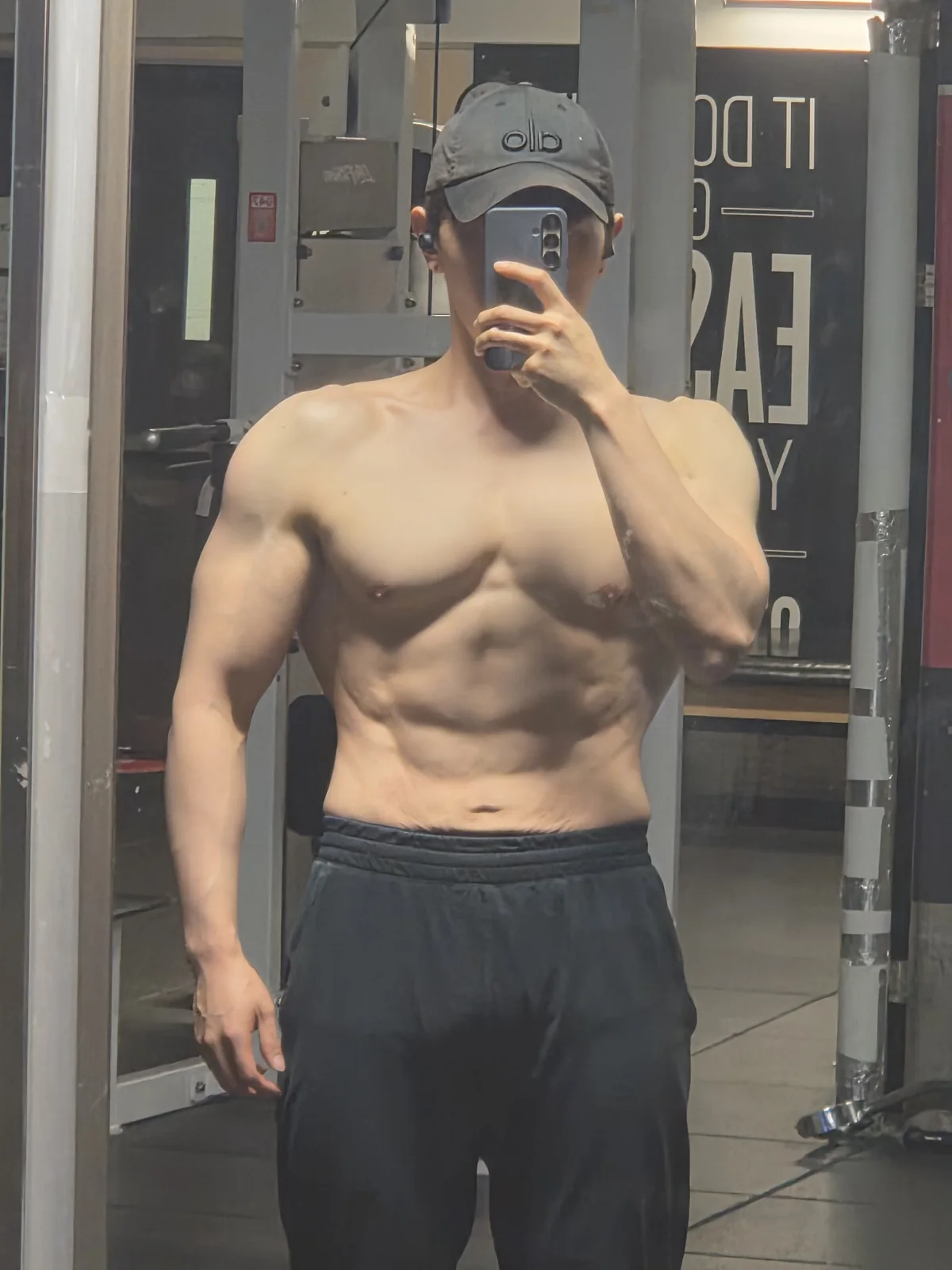 Founder gym mirror physique check-in with visible abdominal definition