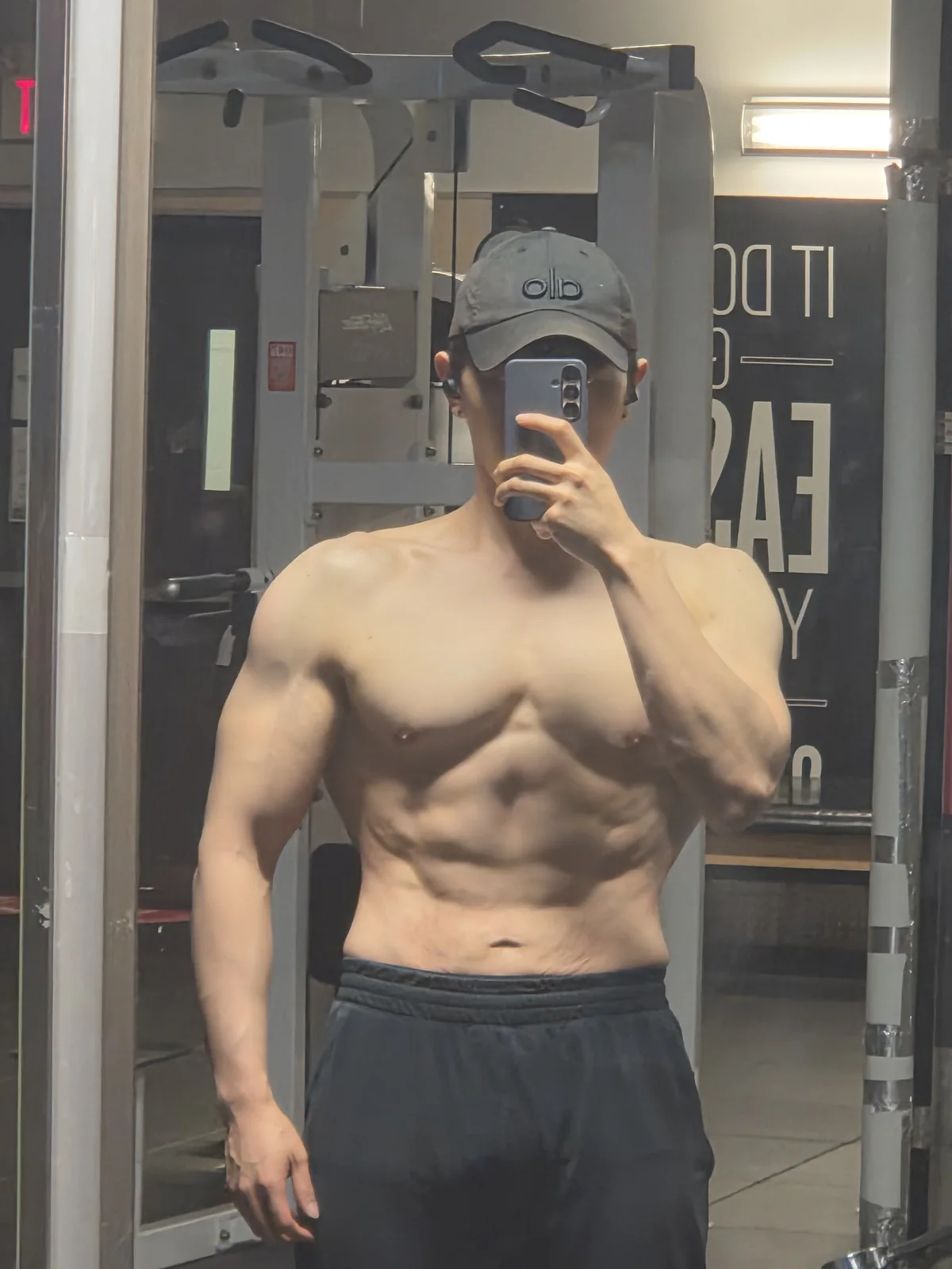 Founder gym mirror physique check-in with visible abdominal definition