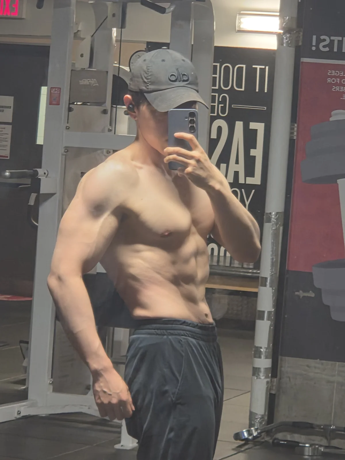 Founder gym mirror physique check-in with visible abdominal definition