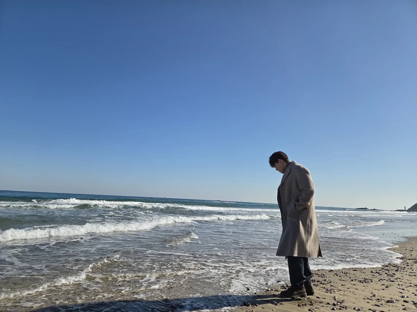 Founder looking down at the shoreline in a winter coat